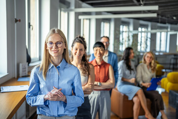 Obraz premium Smiling business team standing together in a modern office