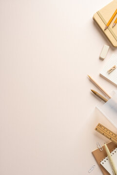 Back to school flatlay with neutral stationery, notebook, pencils and ruler on beige vertical desk for ideas