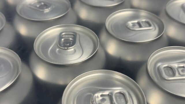 Rows of sealed aluminum cans are grouped in multipacks, creating a clean commercial display suitable for wholesale supply, retail sales and beverage distribution. Close up.