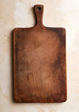 A wooden cutting board in vintage style on a beige kitchen table