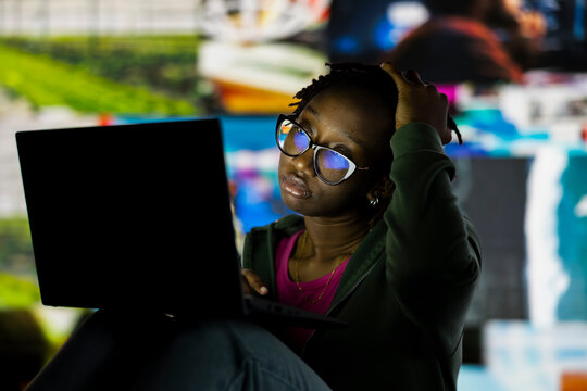 Woman wasting time watching multimedia content all day on laptop; Couch potato person feeling bored after interacting all day with online websites, watching videos on notebook.