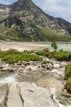 Guttannen, Switzerland. Crystal-clear alpine stream entering Gelmersee with granite rocks and mountain scenery in the Bernese Alps