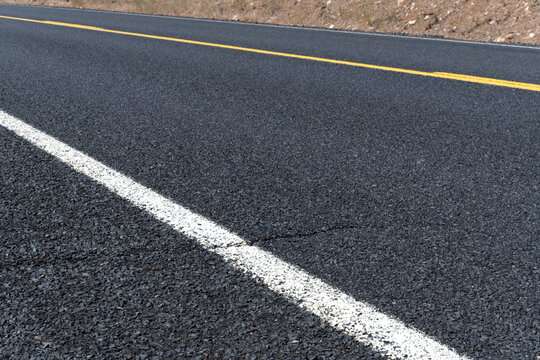 Close diagonal shot of blacktop and lane lines