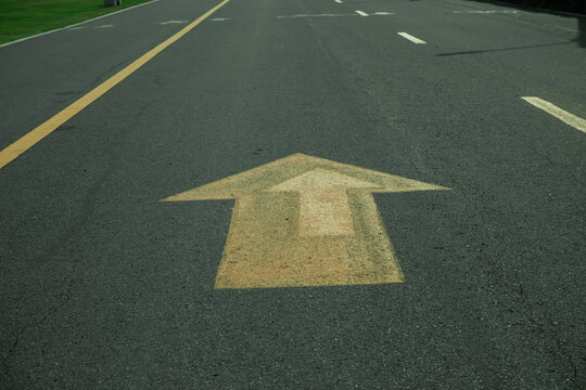 Asphalt road arrow lane marking direction traffic street pavement symbol urban transportation forward guide path on empty roadway with yellow line and dashed mark