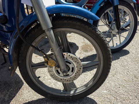 TAVERNES BLANQUES, SPAIN - JUNE 14, 2026.Close up view of front wheel, alloy rim, and Brembo caliper on restored blue Motovespa Vespino moped