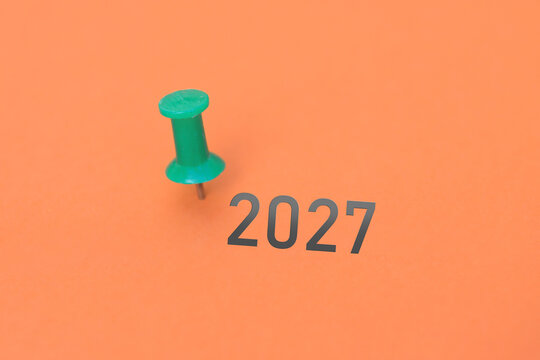 Eine Heftzwecke und ein Blatt Papier mit der Jahreszahl 2027 