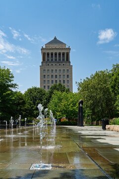 Historic courthouse tower rising above a civic plaza fountain