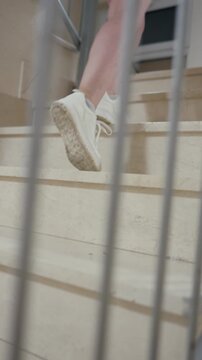 Woman's legs walking up marble stairs