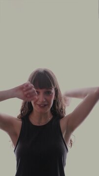 Young woman dancing and looking at camera