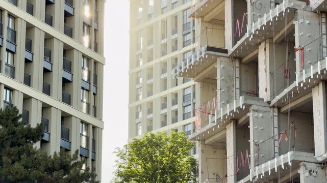 A finished building stands beside an unfinished structure in Simferopol, Crimea. This contrast between the modern facade and the raw frame evokes feelings of growth, progress, and potential.