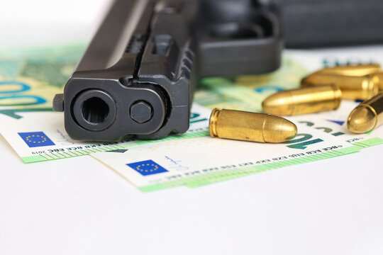 Close-up of a handgun and ammunition resting on euro banknotes. Concept illustrating crime, illegal money, armed robbery, financial crime, violence, security threats and criminal activity.