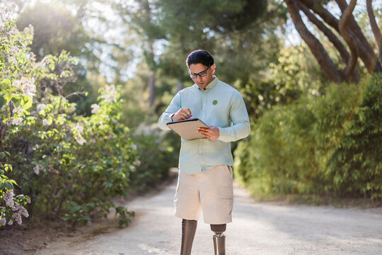 Latino man with prosthetic legs working in park