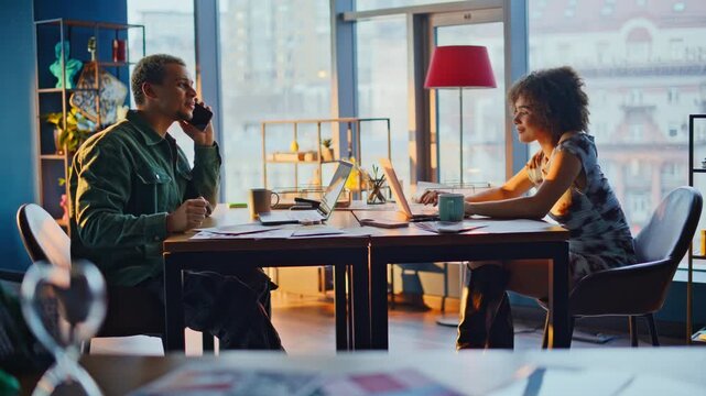 Business partners heated argument in office, man on phone woman gesturing