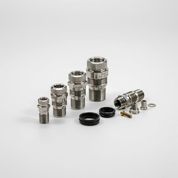Assortment of Metal Cable Glands and Accessories on White Background Keywords: cable gland, metal, industrial, electrical, connector, fitting