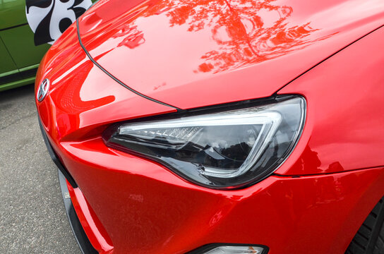 Sharp headlight cluster and red front fascia of Scion FR-S showcases the modern geometric design that made the platform instant icon of 21st-century sports car culture