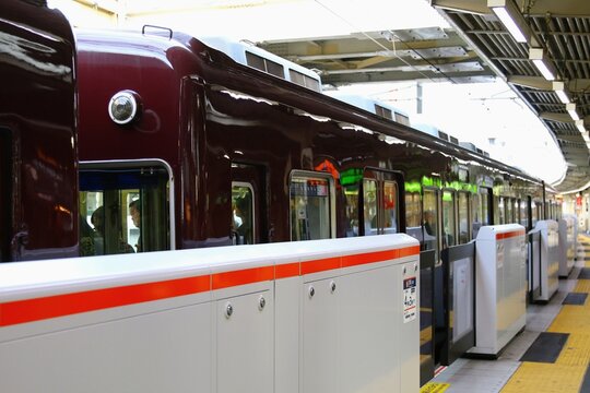 ​駅ホームの可動式ホームドアと停車中の近郊電車