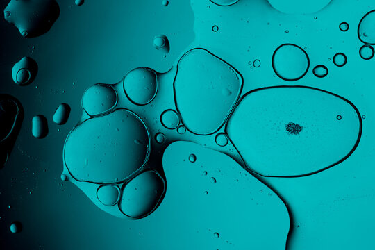 Oil and water creating abstract teal green bubbles