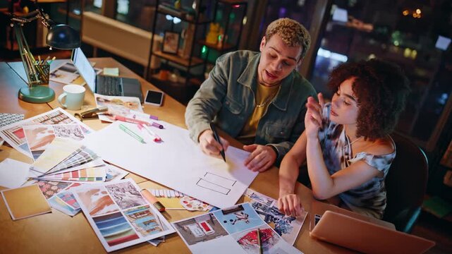 Young designers sketching layout markers evening studio, coworkers planning