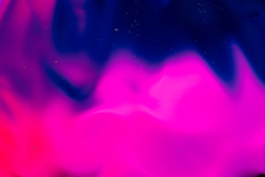 Colorful fluid paint creating abstract vibrant background design