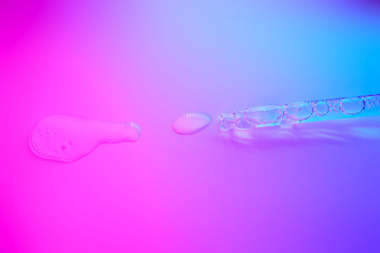 Cosmetic serum liquid and dropper on vibrant gradient background