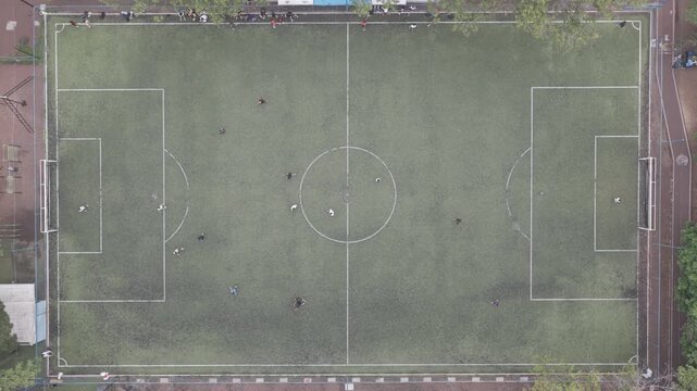 Top-Down Aerial View of Players on Football Field as Drone Hovers Overhead