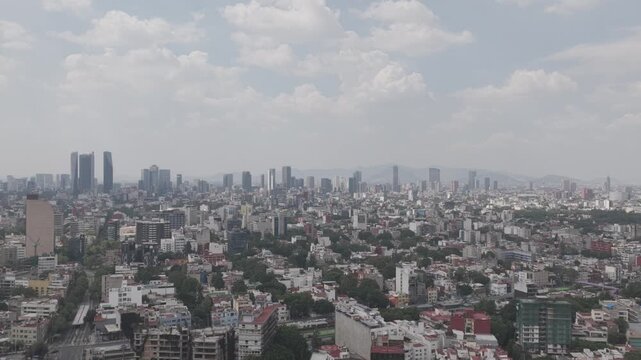 Aerial panoramic view flying forward over southern Mexico City with Paseo de la Reforma skyline in background, shot in D-Log M