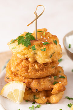 Crispy Golden Cod Fritters Stacked on Plate