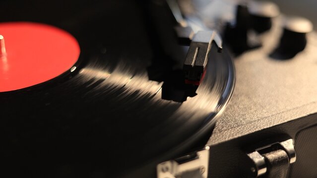 Close-up of a spinning vinyl record on a turntable with a red label