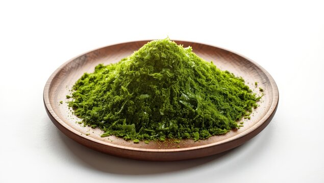 Green nori seaweed powder flakes in a wooden dish on a white background.