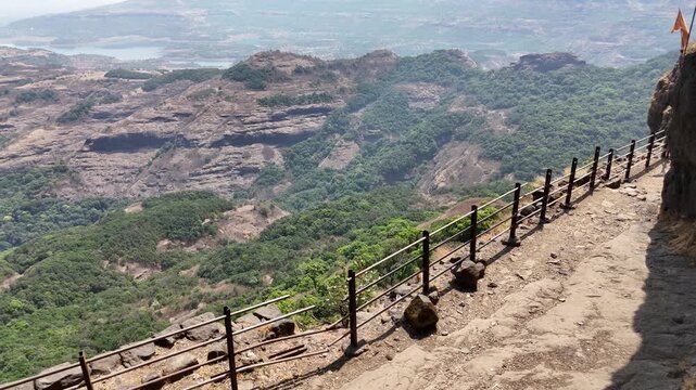 Ratangad fort trail and saffron flag on the cliff edge India