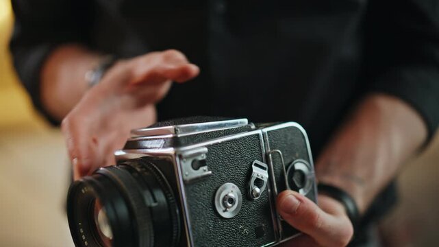 Vintage medium format film camera in man hands. Close up retro analog gear.