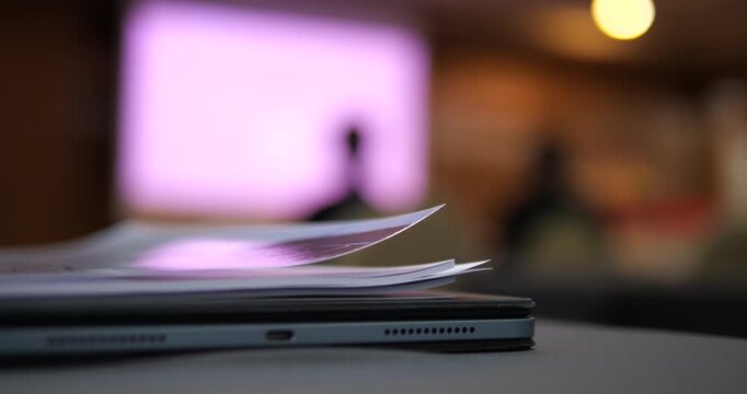 Close up of paper documents on table with blurred conference room background