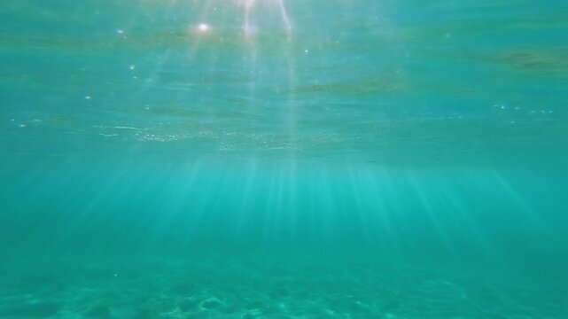 Sunlight rays underwater in turquoise sea at Cala Pi Mallorca