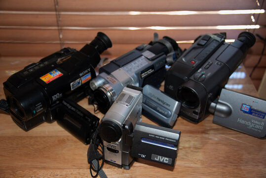 North Haven, South Australia - February 9 2022: Four vintage retro camcorders on a wooden table