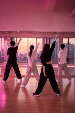 Young dance group practicing synchronized choreography in a Seoul studio at sunset