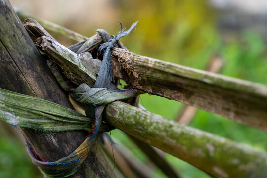Detailed close up of a cloth knot tying a rustic bamboo fence