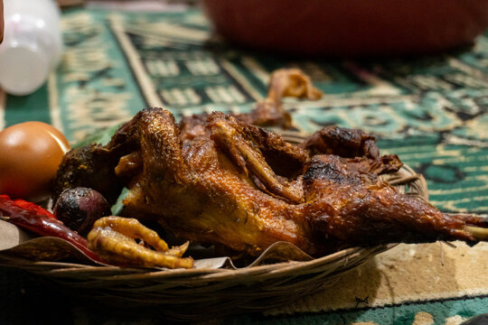 Traditional Indonesian fried chicken served on a woven bamboo plate