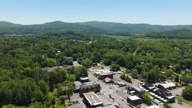 Aerial footage captures Brevard, North Carolina, highlighting lush greenery, residential neighborhoods, and commercial districts with clear skies above