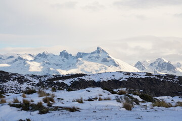Fototapeta premium Snow covered jagged mountain peaks under winter sky in Ushuaia Patagonia Argentina