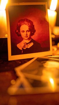 Antique portrait of lady resting near burning candles.