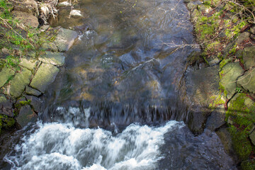 Flowing water stream cascading over mossy rocks © FlorianSchultze