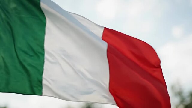Italian flag waving in the wind against blue sky