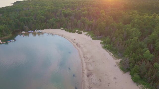 Bruce Penisula, Canada - July 8 2026: A stunning 4K aerial drone view of Singing Sands Beach in the Bruce Peninsula, showcasing shallow turquoise waters, soft sandy shores, and lush coastal forests.