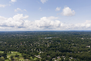 Obraz premium Aerial drone view of golf course fairways, nearby homes, and mature trees in Bayberry Park, New Rochelle, New York