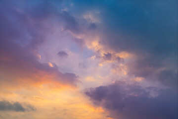 Obraz premium Clouds illuminated by a colorful sunset with golden, pink and blue tones. Natural background for weather, landscape, design and atmospheric concepts.