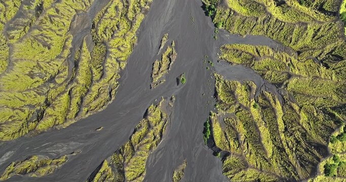 Aerial view volcanic landscape on Ambrym Island, Vanuatu, showing dark solidified lava channels winding through mossy green terrain, highlighting the raw geological forces shaping the earth's surface