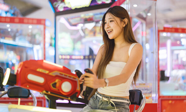 Enjoy teenager woman playing arcade game center