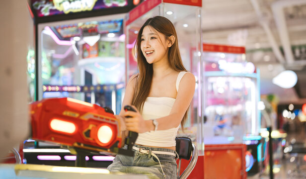Enjoy teenager woman playing arcade game center