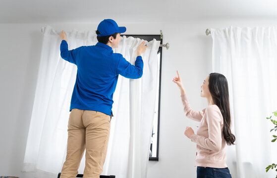 若い女性の引っ越しを請け負う若い業者　ライフスタイルイメージ