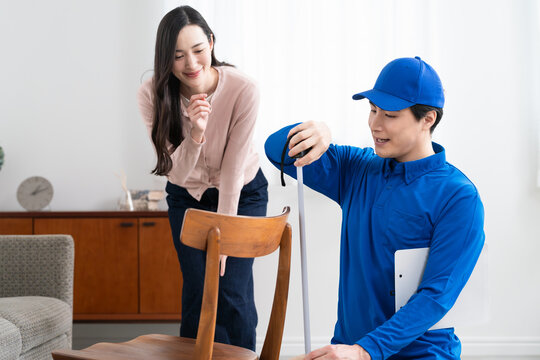 若い女性の引っ越しの見積もりをする若い業者　ライフスタイルイメージ